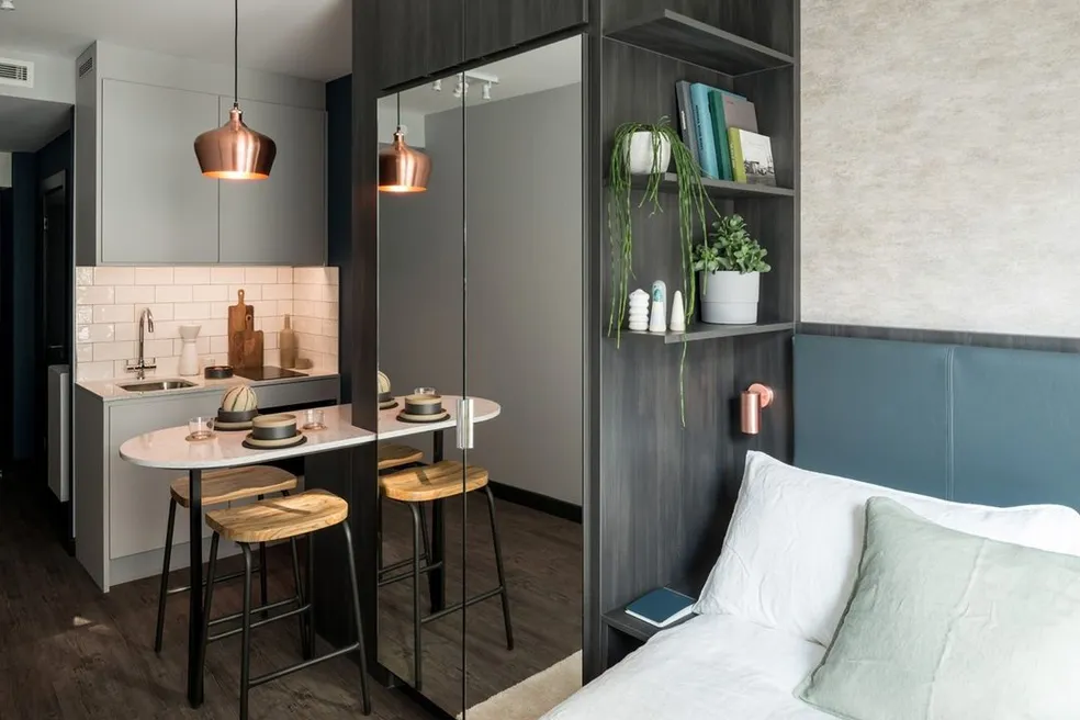 Photo of a small room with a closet, table, chair and sofa.